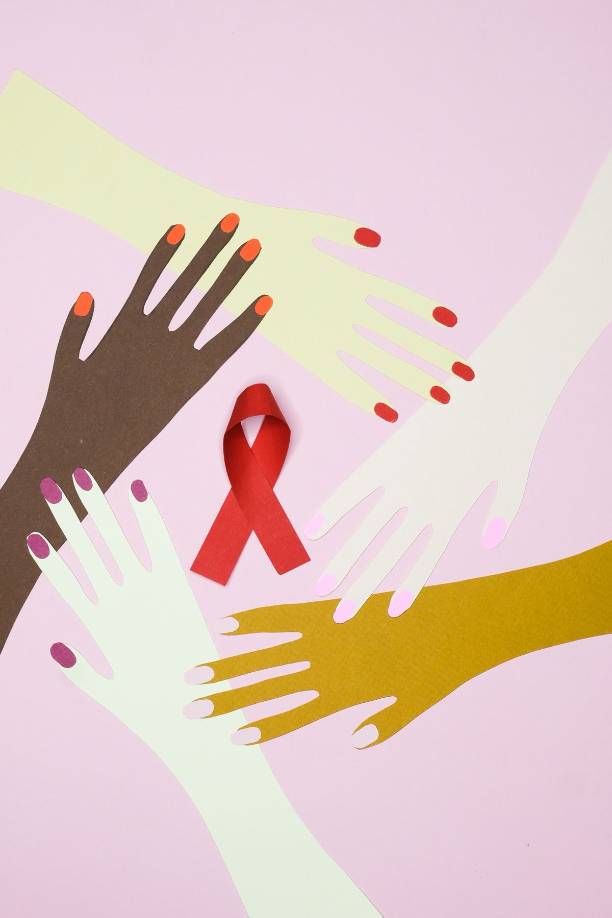 Paper cut-out hands around a red ribbon